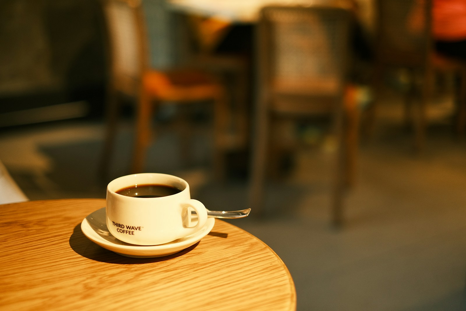 A ceramic coffee cup on a wooden café table